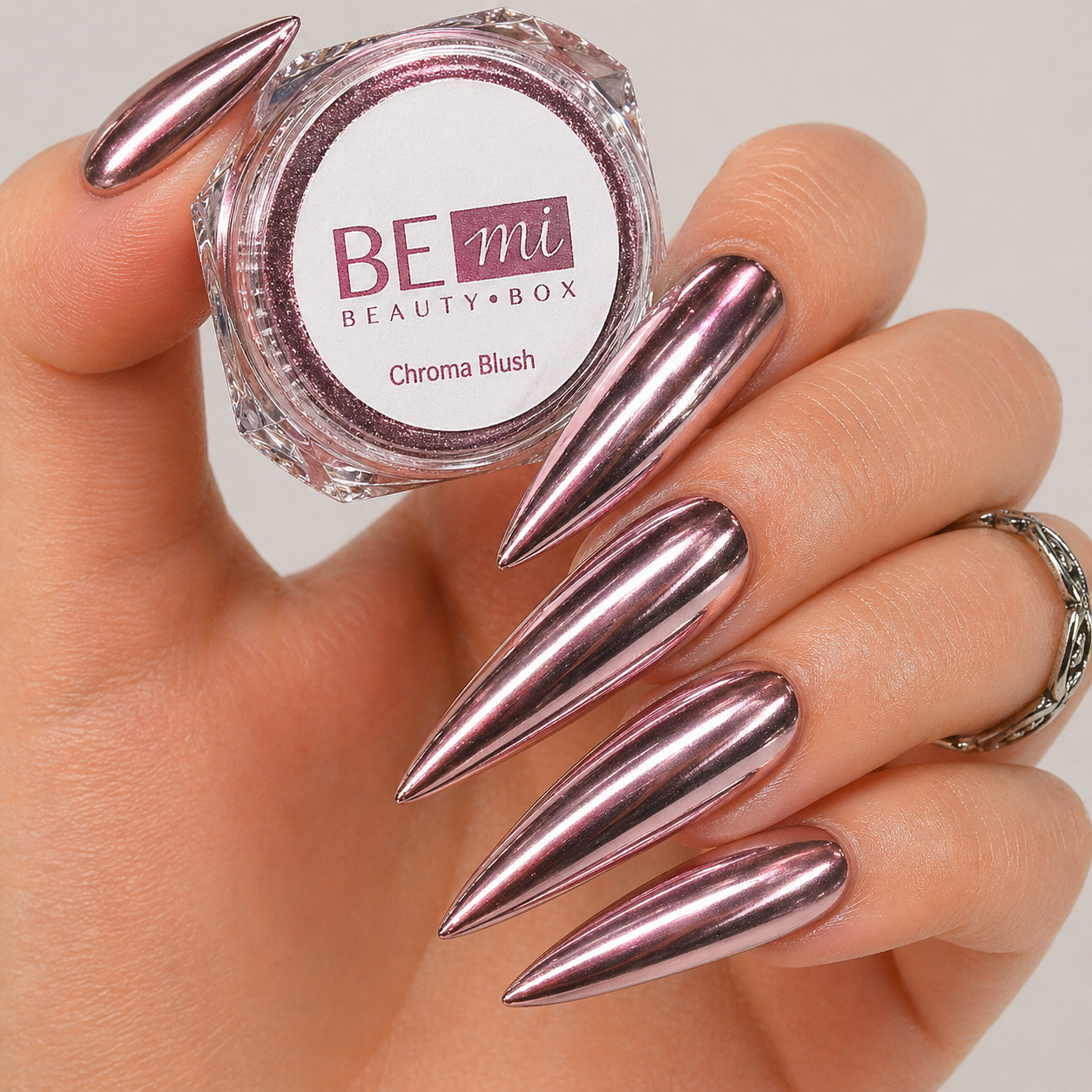 Finished manicured nails with a high-shine liquid metal effect using BEMI Chrome in Chroma Blush, burnished flawlessly over a gel base for professional nail artistry.