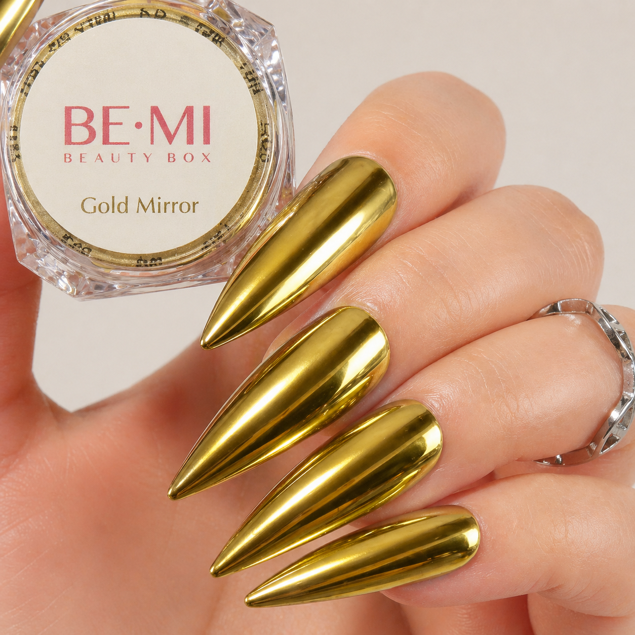Finished manicured nails with a high-shine liquid metal effect using BEMI Chrome in Gold Mirror, burnished flawlessly over a gel base for professional nail artistry.