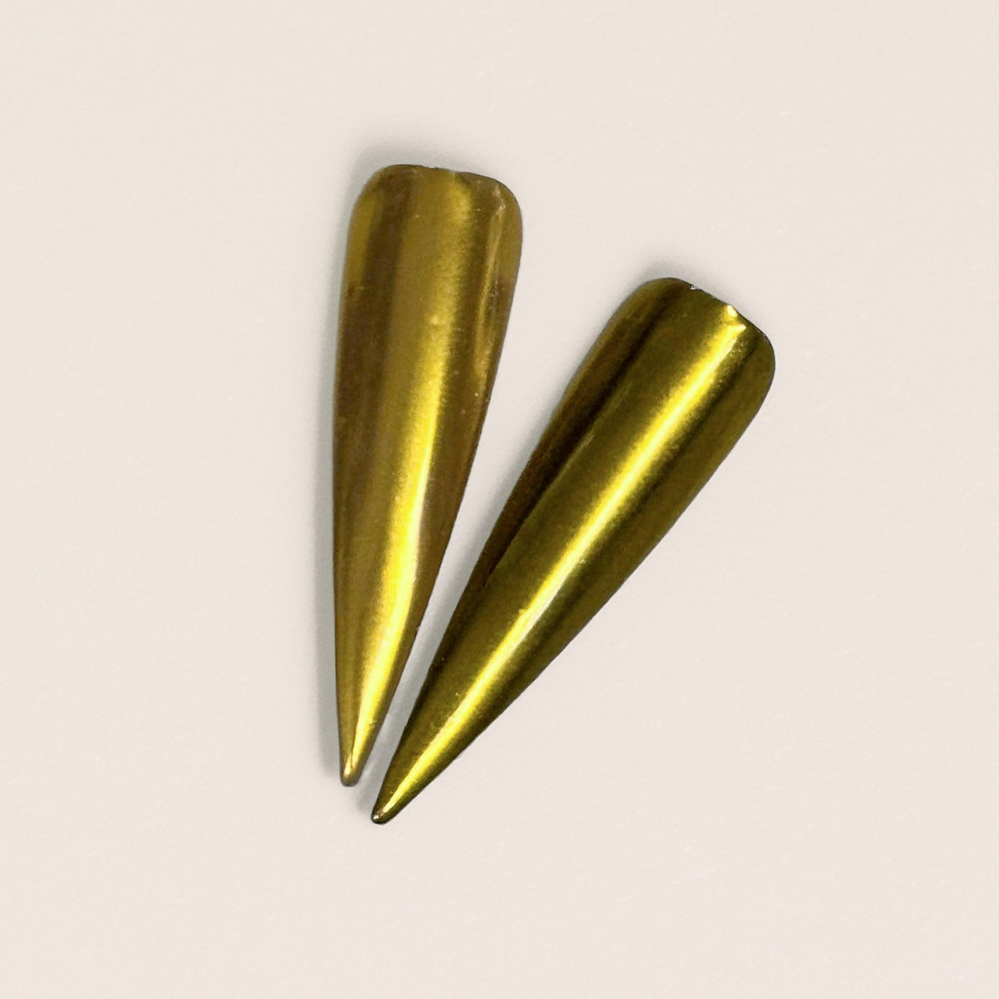 Finished manicured nails with a high-shine liquid metal effect using BEMI Chrome in Gold Mirror, burnished flawlessly over a gel base for professional nail artistry.