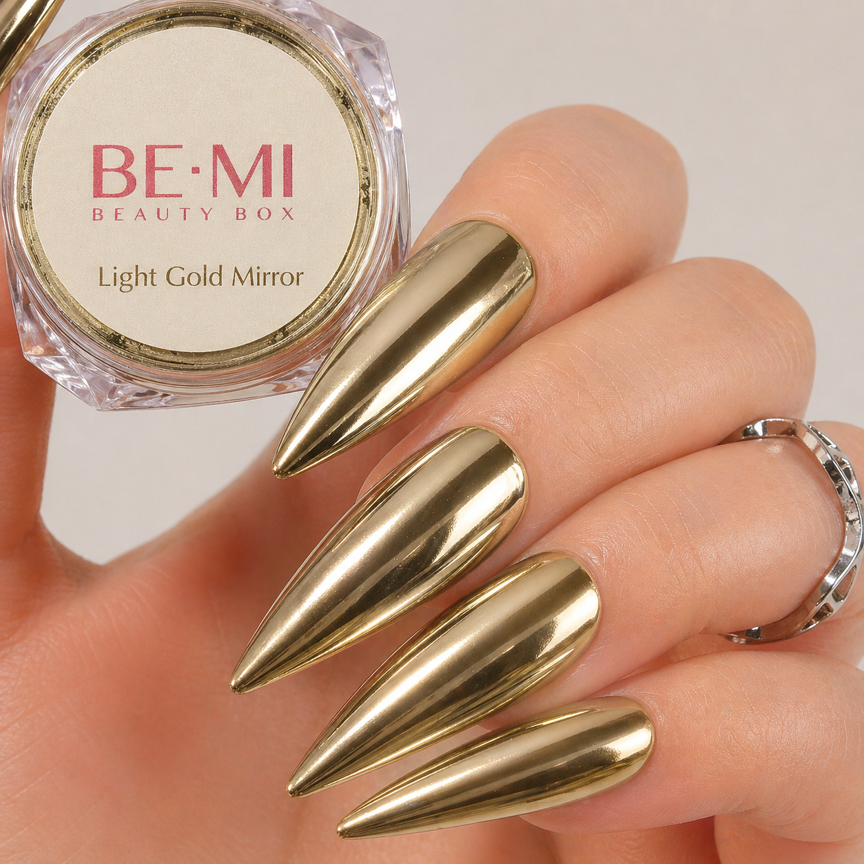 Finished manicured nails with a high-shine liquid metal effect using BEMI Chrome in Light Gold Mirror, burnished flawlessly over a gel base for professional nail artistry.