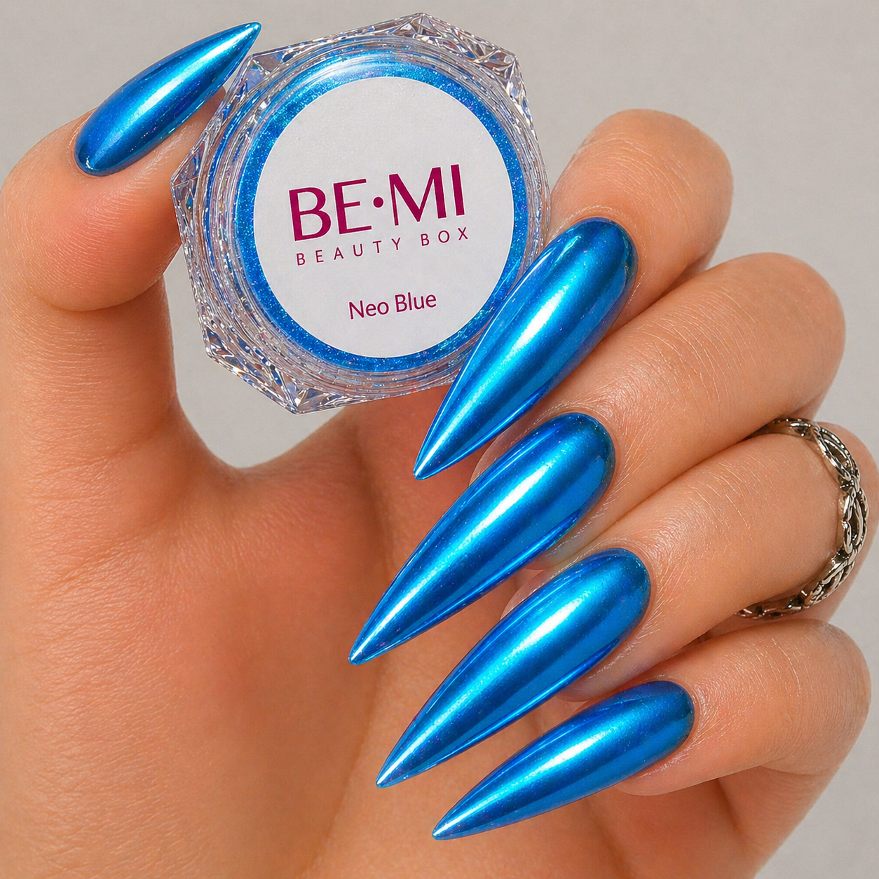 Finished manicured nails with a high-shine liquid metal effect using BEMI Chrome in Neo Blue, burnished flawlessly over a gel base for professional nail artistry.