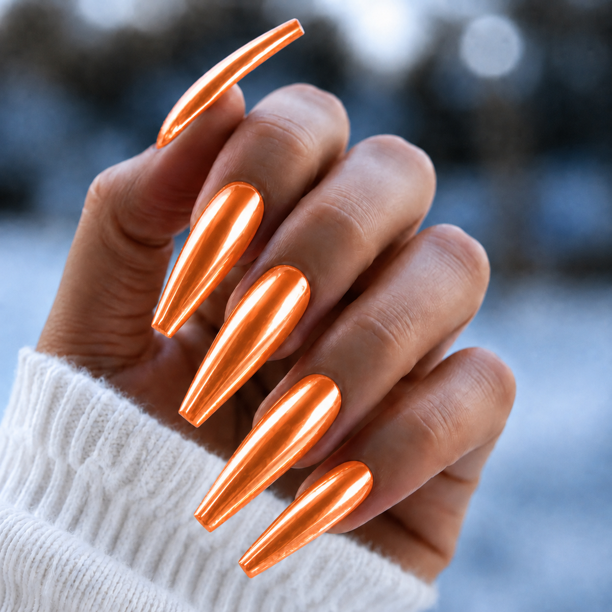Finished manicured nails with a high-shine liquid metal effect using BEMI Chrome in Neo Orange, burnished flawlessly over a gel base for professional nail artistry.