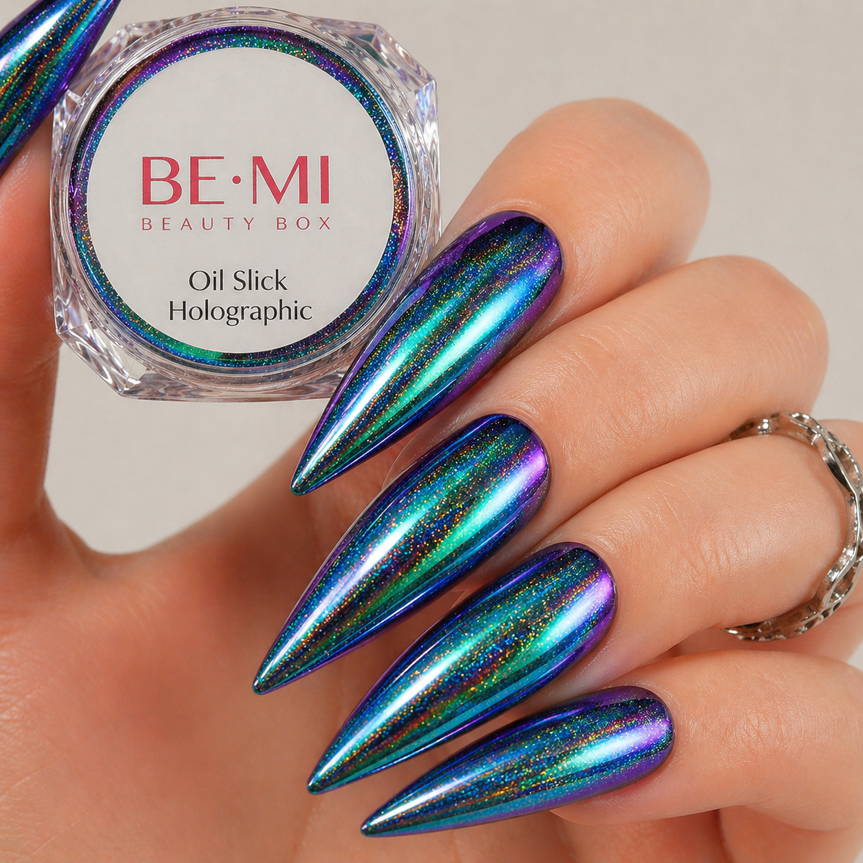 Finished manicured nails with a high-shine liquid metal effect using BEMI Chrome in Holo Oil Slick, burnished flawlessly over a gel base for professional nail artistry.