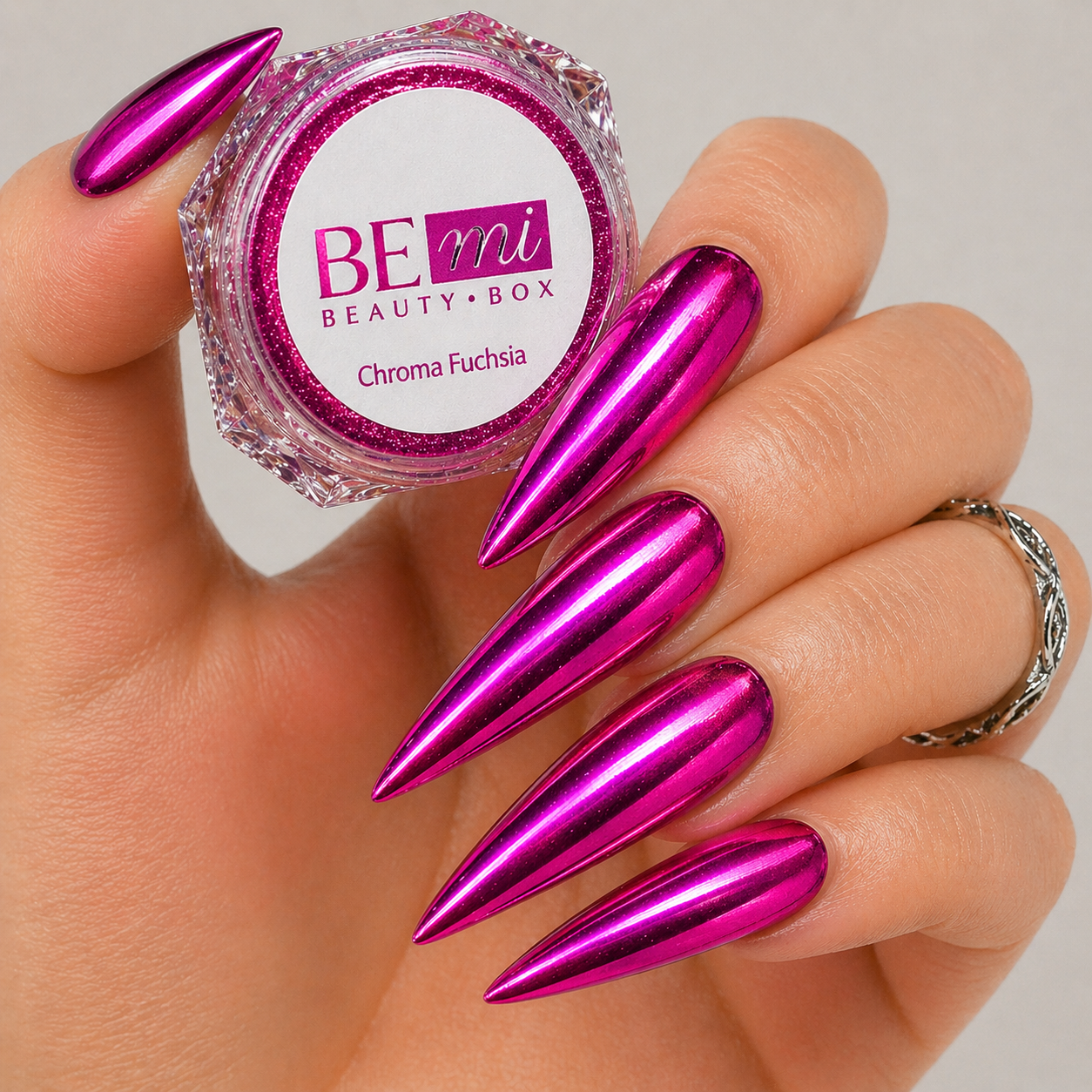 Finished manicured nails with a high-shine liquid metal effect using BEMI Chrome in Chroma Fuchsia, burnished flawlessly over a gel base for professional nail artistry.