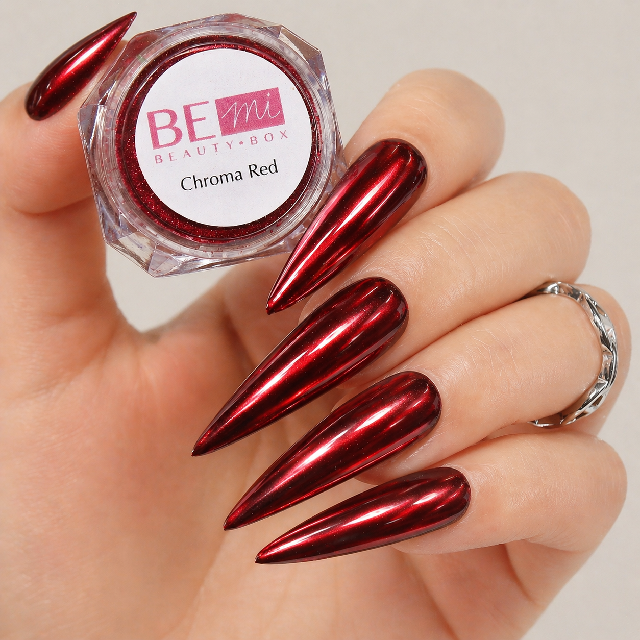 Finished manicured nails with a high-shine liquid metal effect using BEMI Chrome in Chroma Red, burnished flawlessly over a gel base for professional nail artistry.