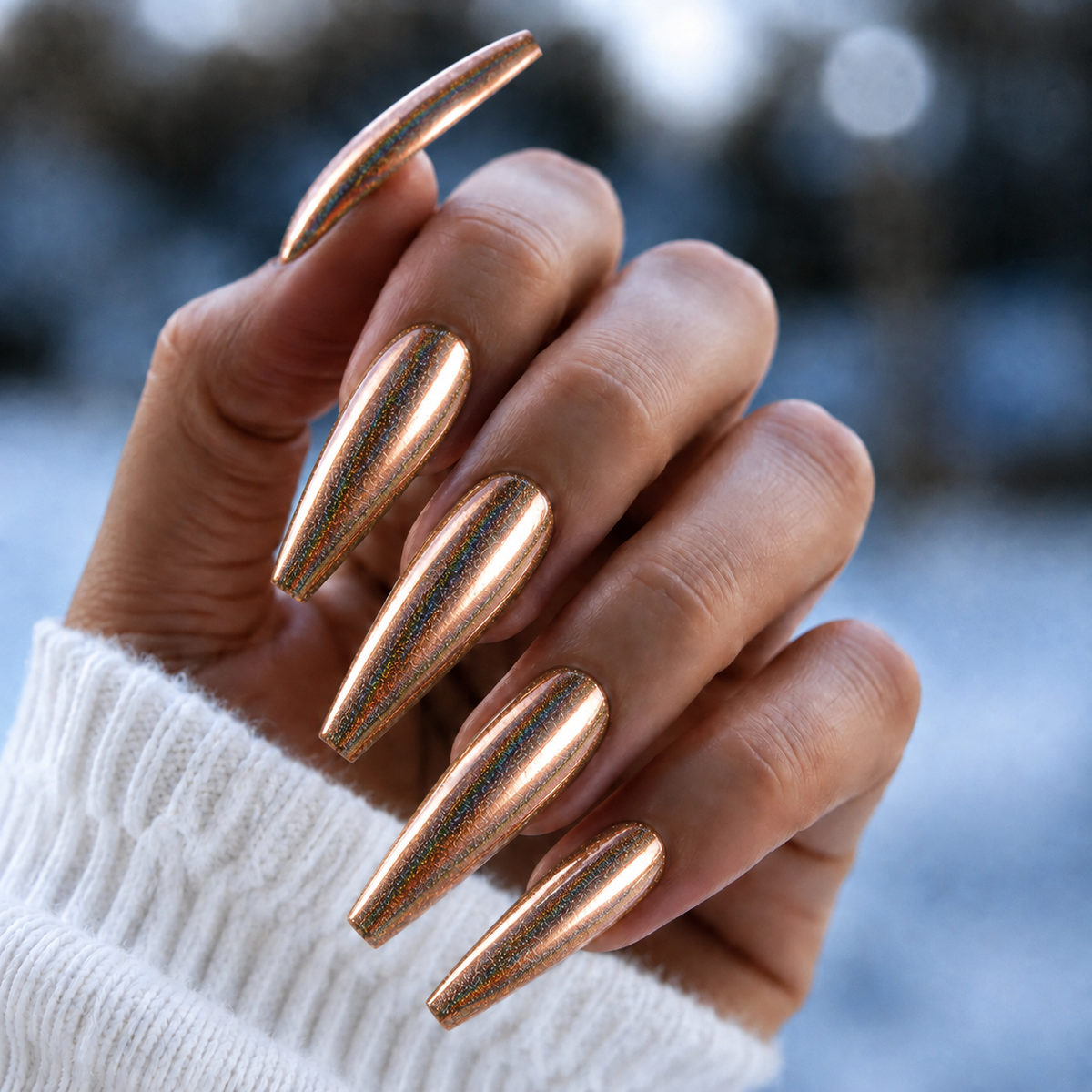 Finished manicured nails with a high-shine liquid metal effect using BEMI Chrome in Rose Gold Holo, burnished flawlessly over a gel base for professional nail artistry.