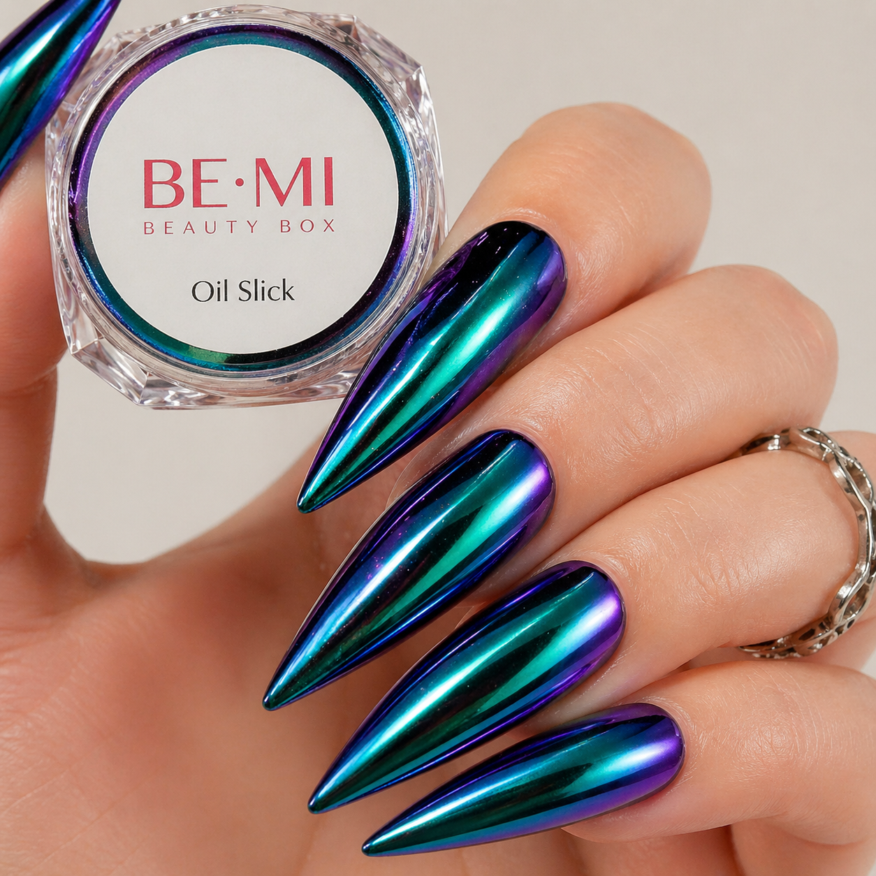 Finished manicured nails with a high-shine liquid metal effect using BEMI Chrome in Oil Slick, burnished flawlessly over a gel base for professional nail artistry.