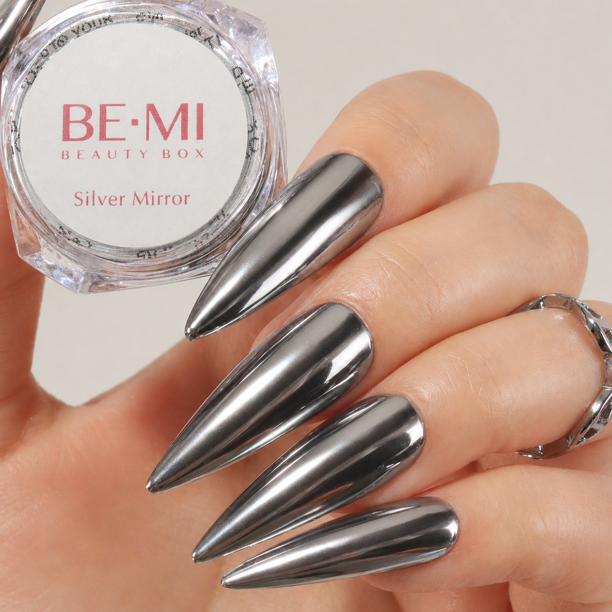 Finished manicured nails with a high-shine liquid metal effect using BEMI Chrome in Silver Mirror, burnished flawlessly over a gel base for professional nail artistry.