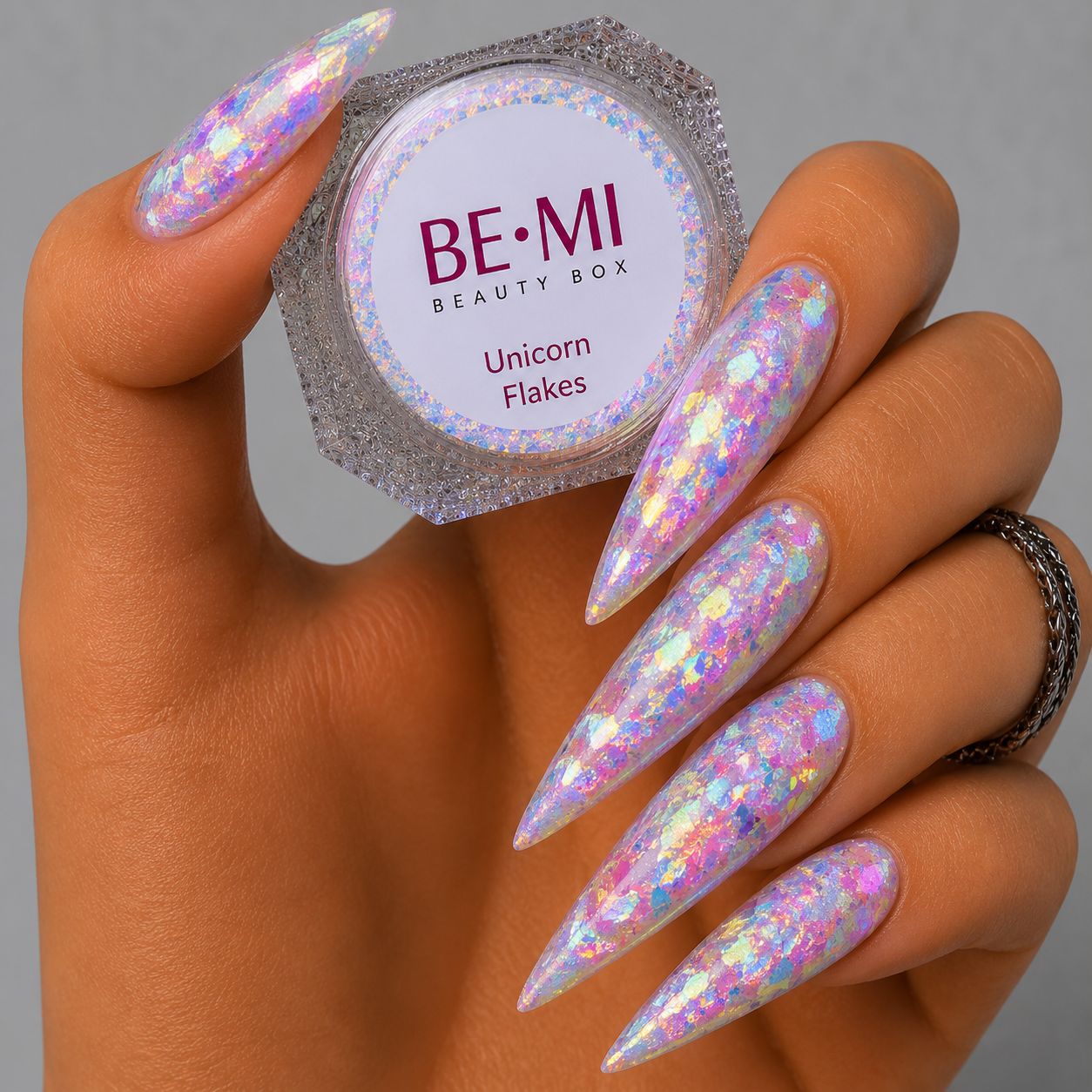 Finished manicured nails with a high-shine liquid metal effect using BEMI Chrome in Unicorn Flakes, burnished flawlessly over a gel base for professional nail artistry.