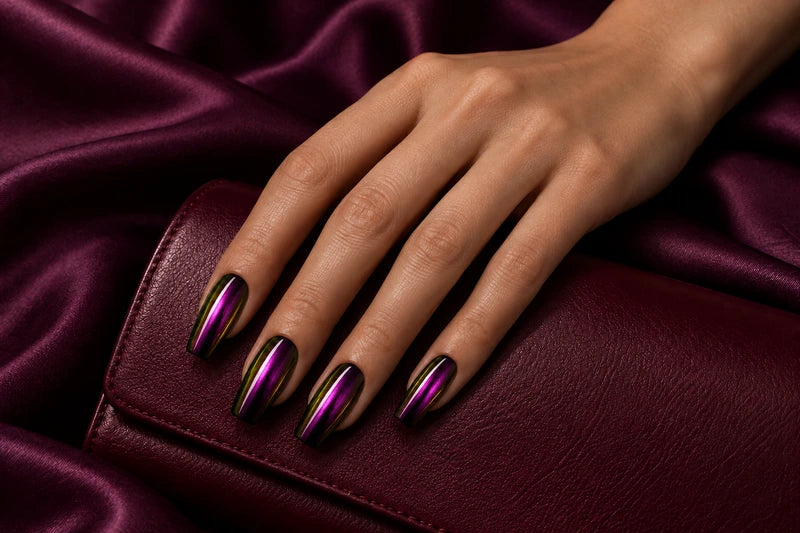 Chrome Bloom magenta and gold nails on a burgundy clutch and plum satin