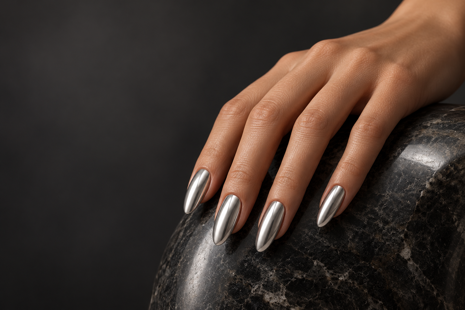 Silver Mirror chrome nails resting on polished dark stone